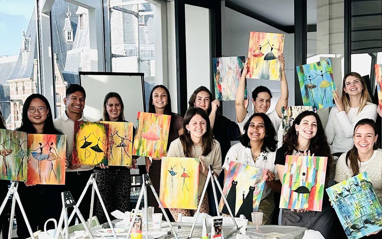 Een volledige Art Café-dag in een echt kantoor — ezels, verf en een team met hun canvassen in de hand